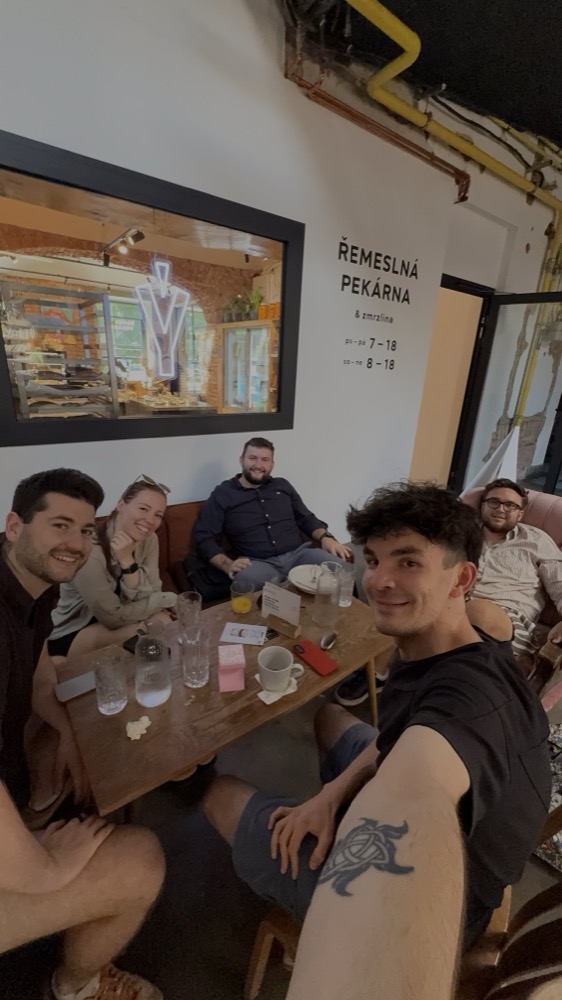 Snídaňový sraz 18. 6. v pekárně, šest lidí u stolu